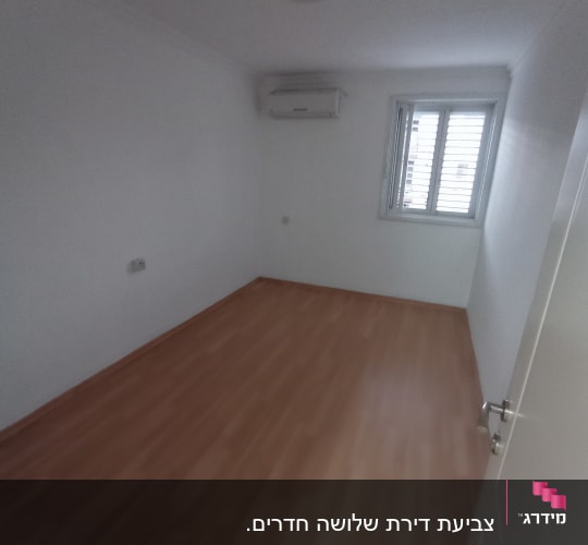 חדר ריק עם קירות לבנים ורצפת עץ